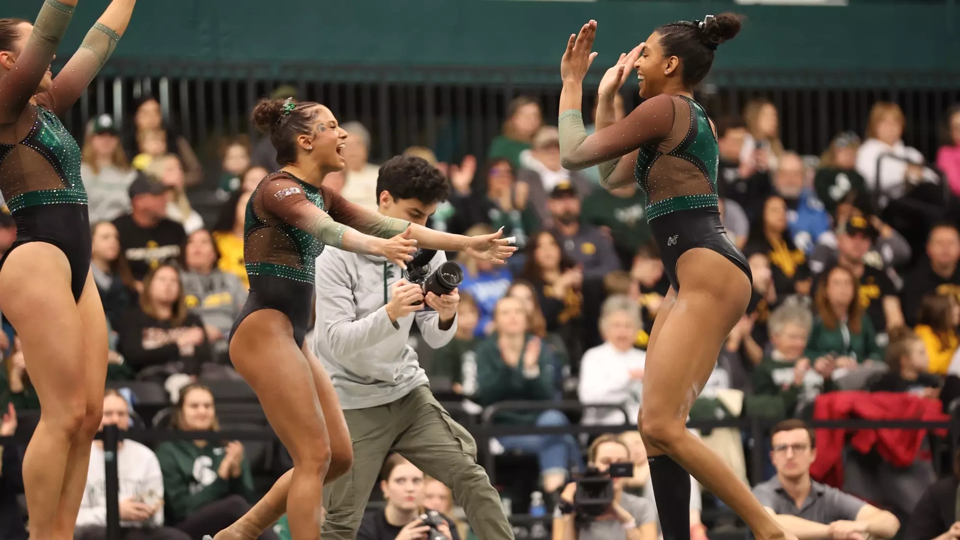 MaKayla Tucker high-fiving a Michigan State teammate in front of a packed home crowd