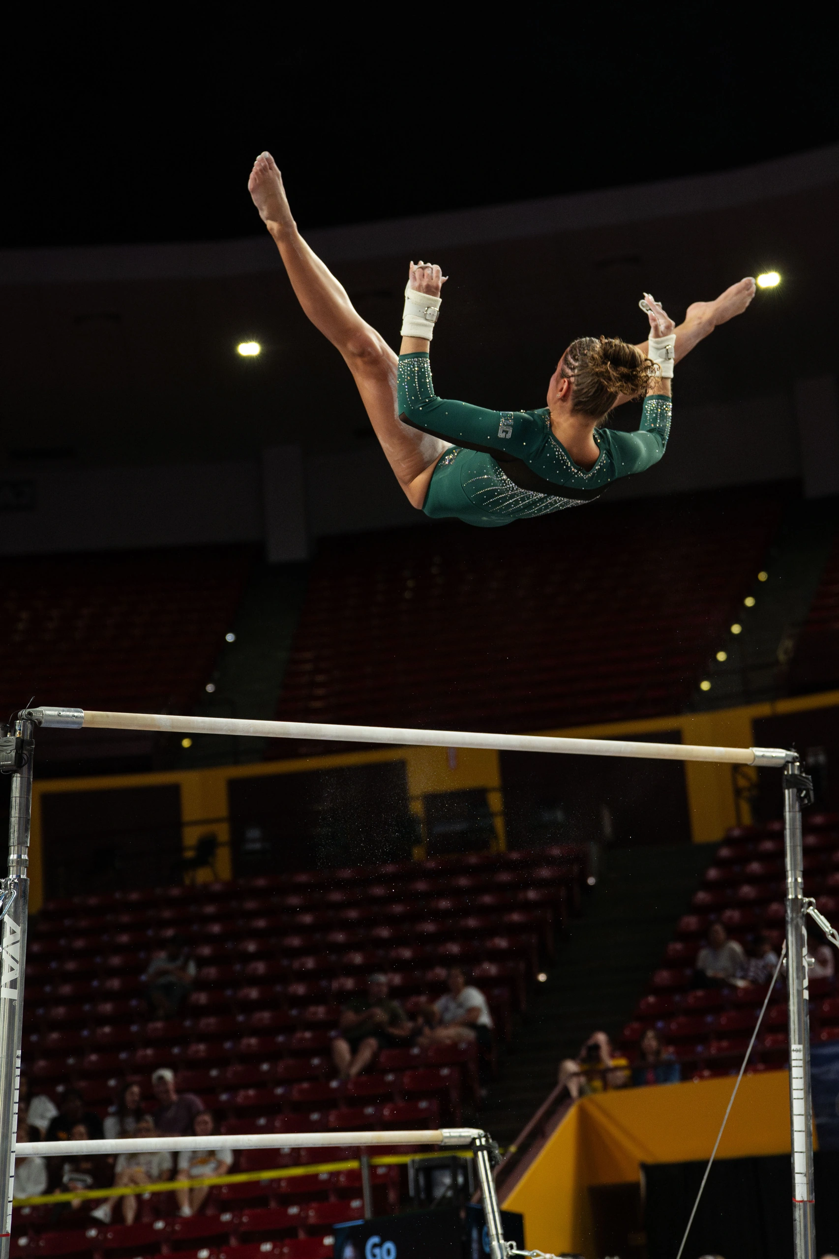 Sage Kellerman mid-air in a bars release during a Michigan State meet
